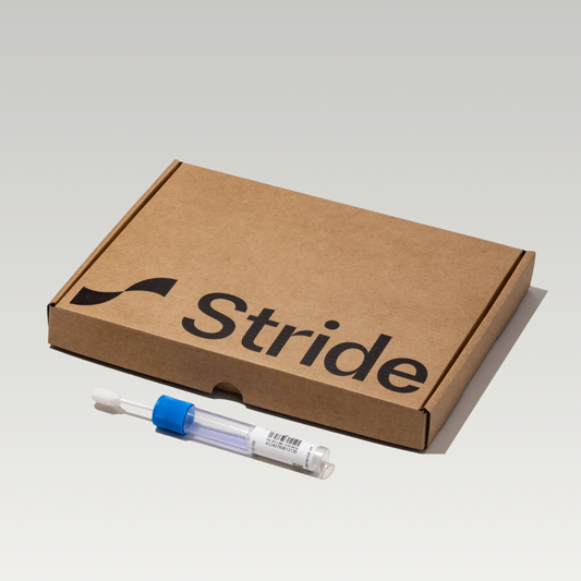 A StrideDNA Optimal Health test kit, including a cheek swab sample collection tube and a packaging box with the brand logo visible.